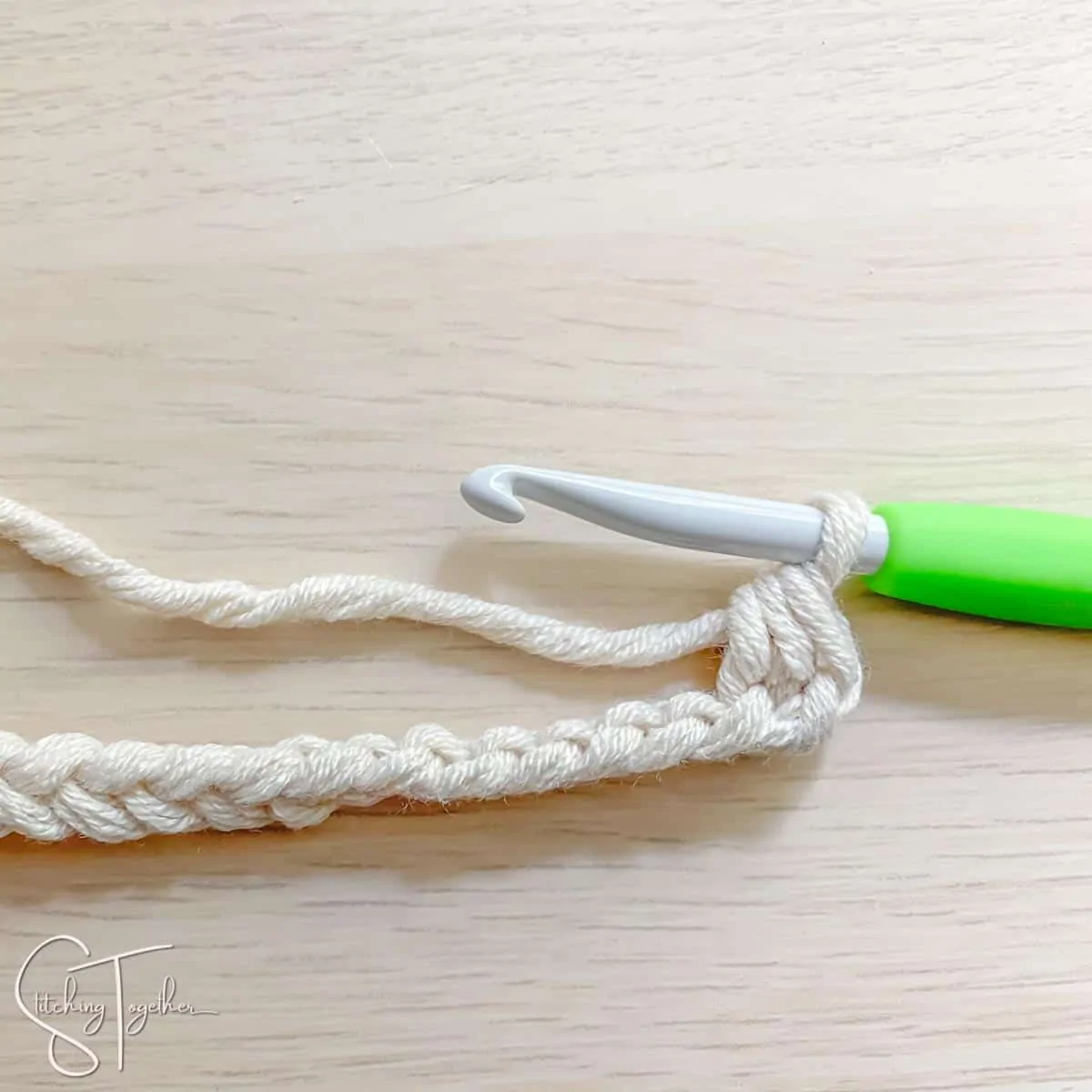 crochet hook and yarn showing the steps for a mhdc3tog