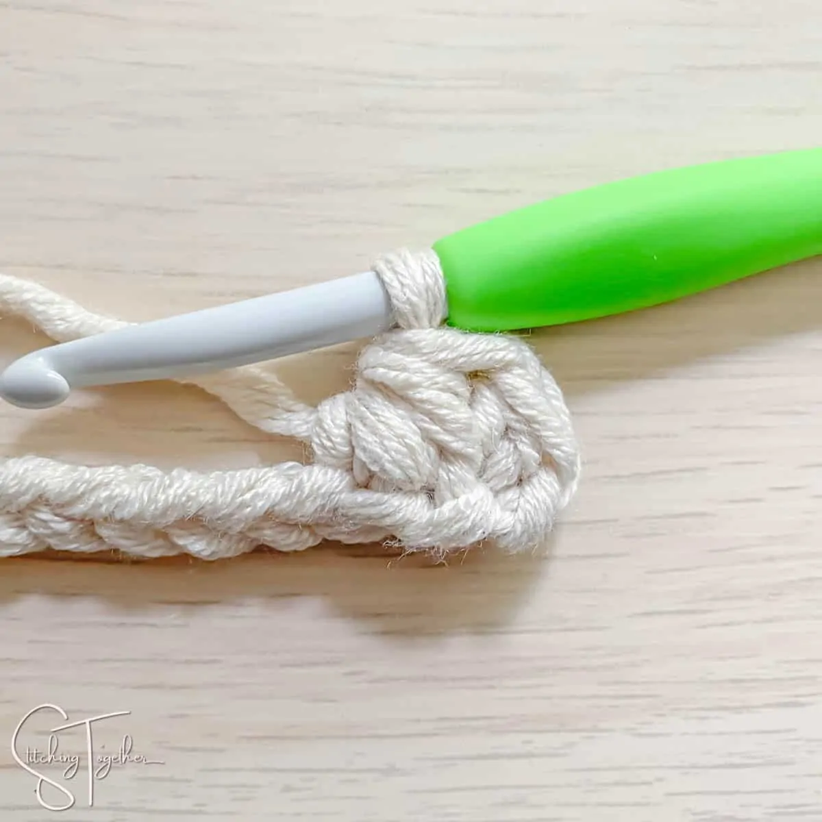 crochet hook and yarn showing the steps for a mhdc3tog