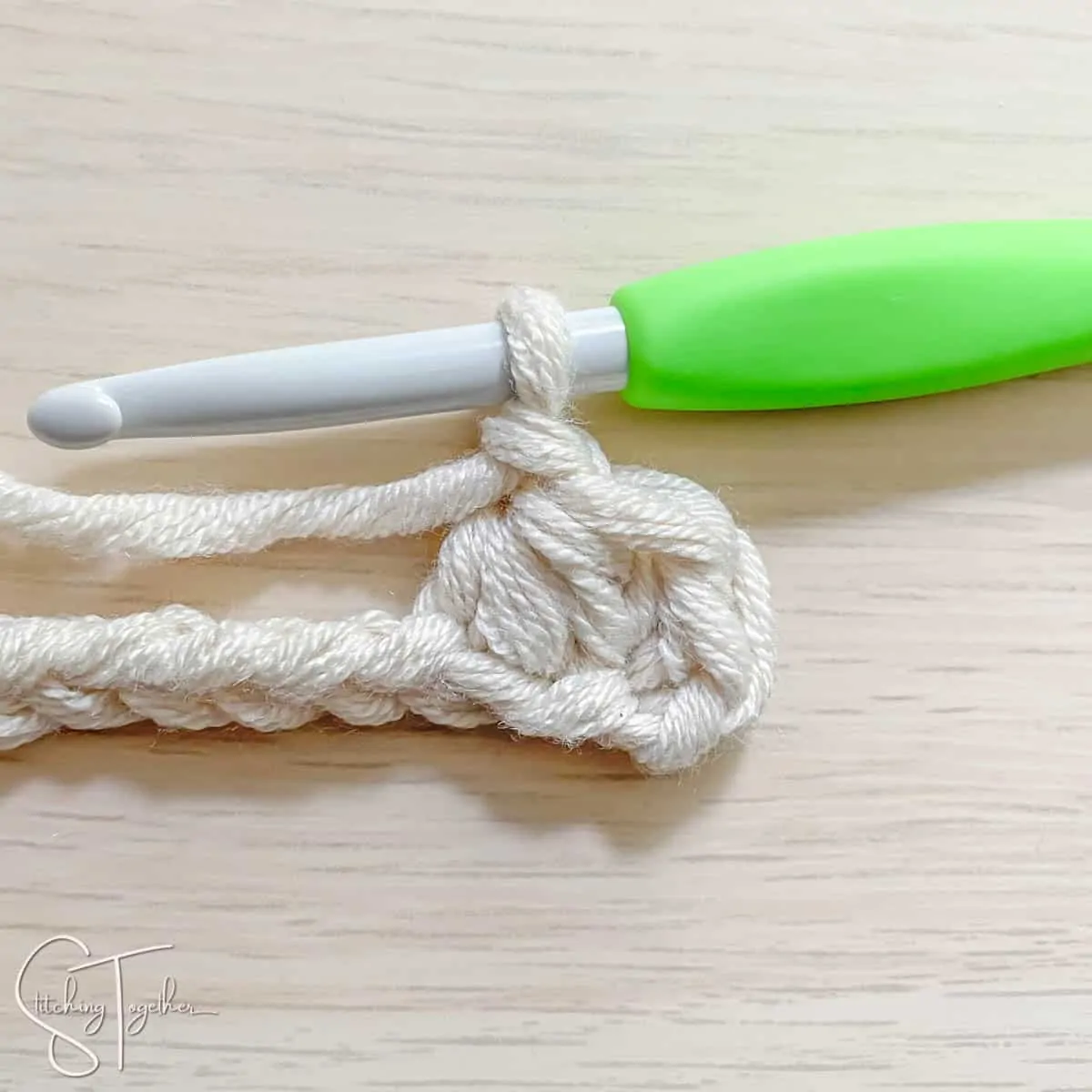 crochet hook and yarn showing the steps for a mhdc3tog