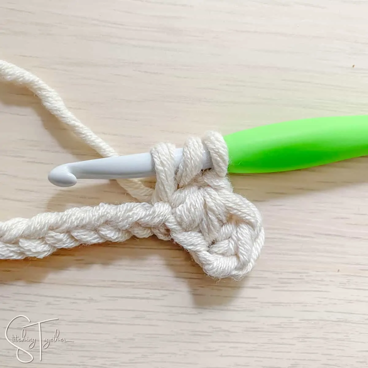 crochet hook and yarn showing the steps for a mhdc3tog