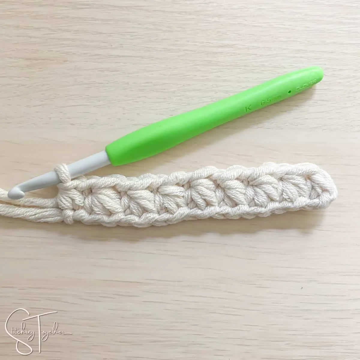 crochet hook and yarn showing the steps for a mhdc3tog