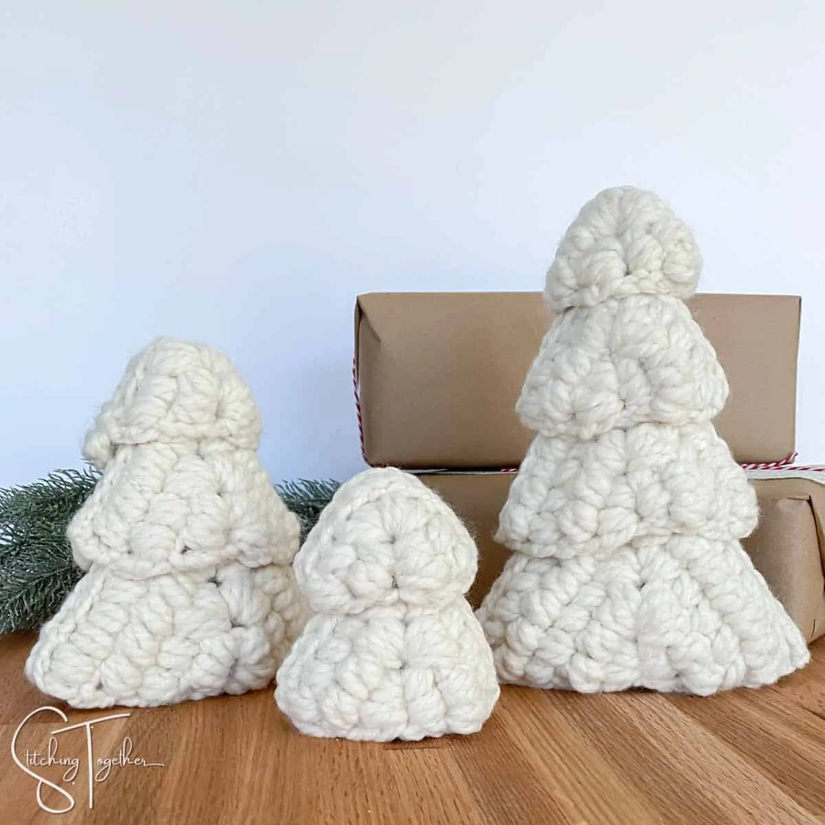 3 large crochet Christmas tree in front of presents