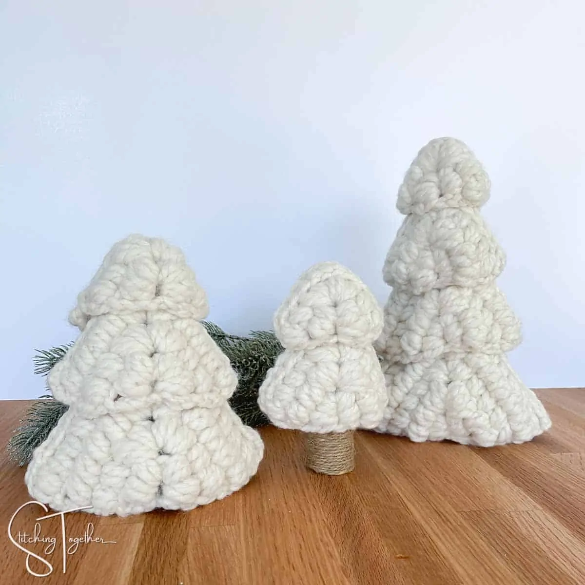3 christmas trees made with chunky white yarn