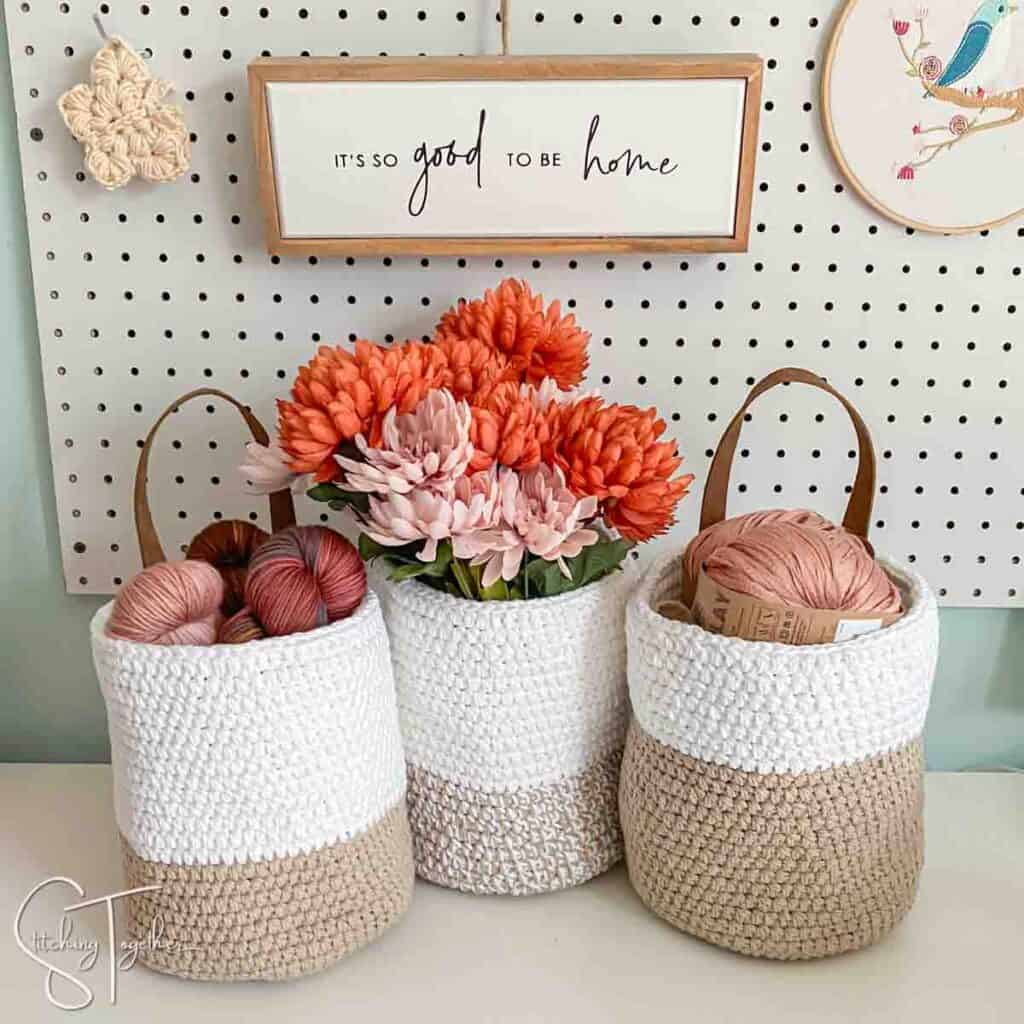 3 cestos de crochê em uma prateleira cheia de fios ou flores