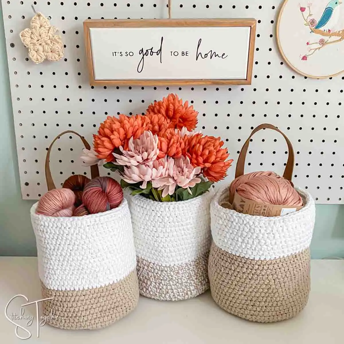 3 crochet baskets sitting on a shelf filled with yarn or flowers