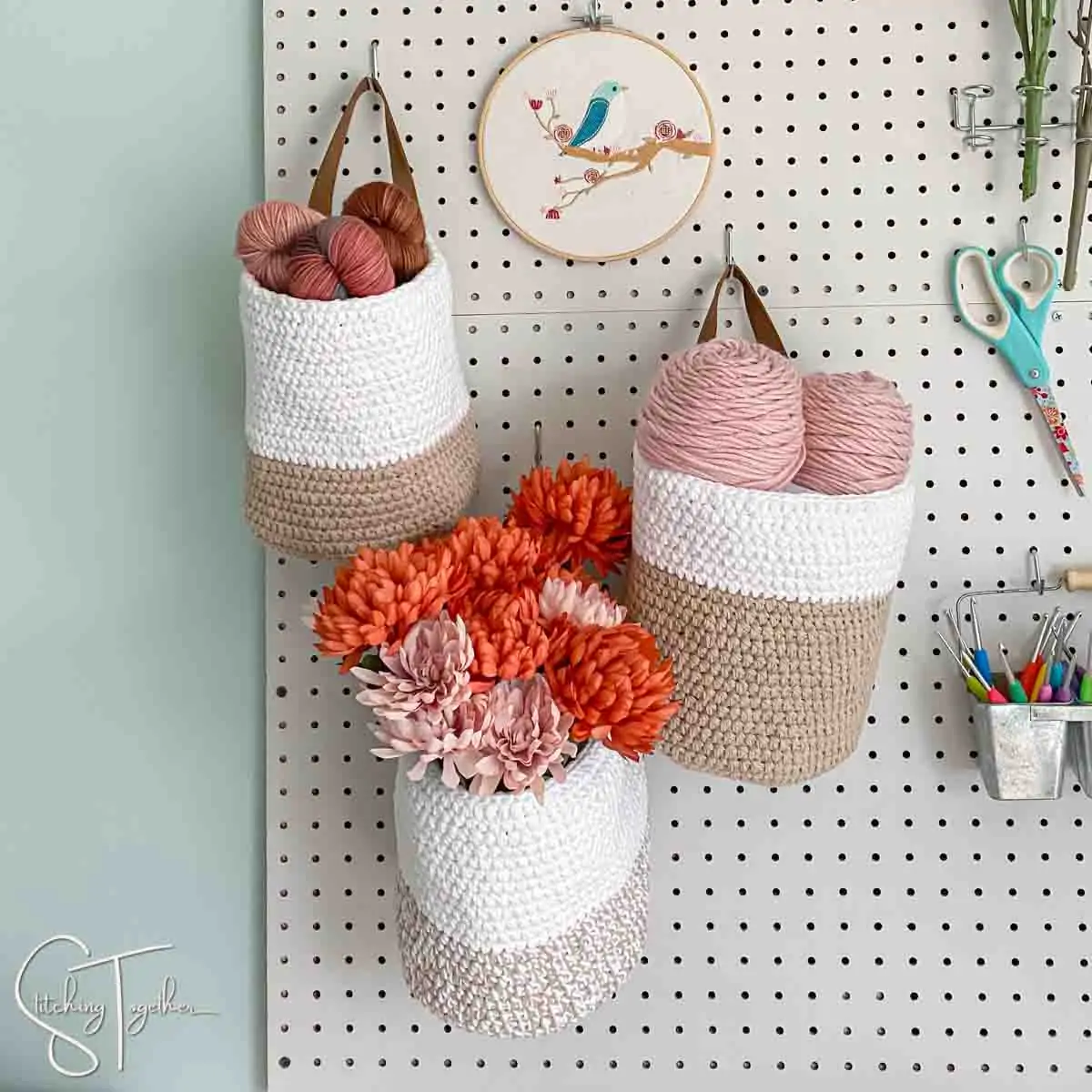 3 hanging crochet baskets on a pegboard