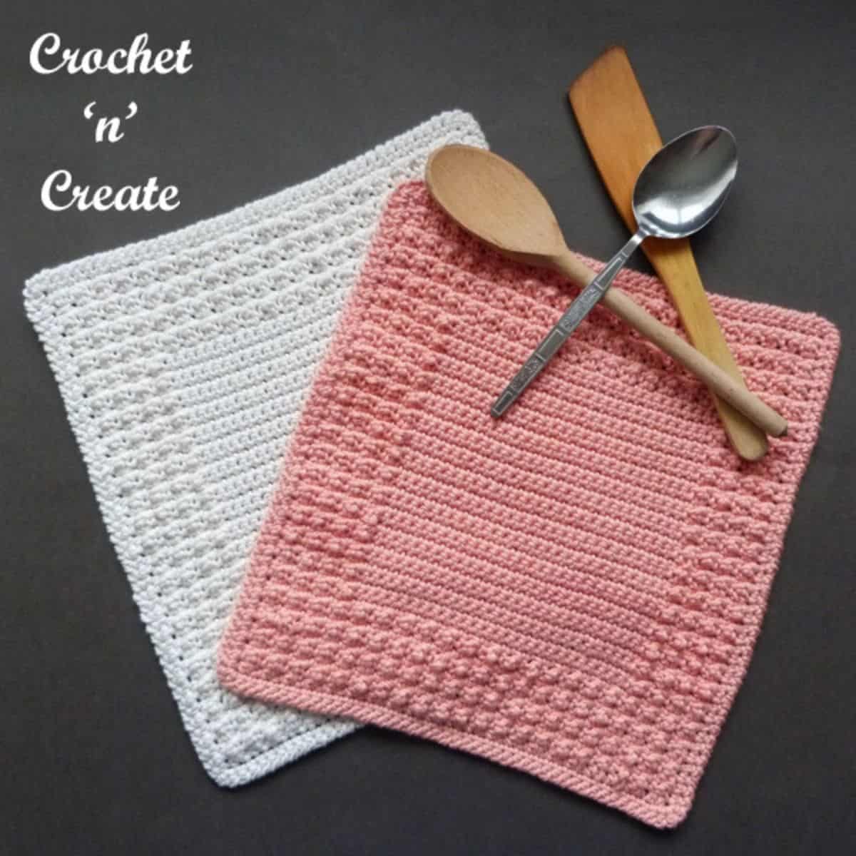 two crochet dishcloths with utensils styled on top