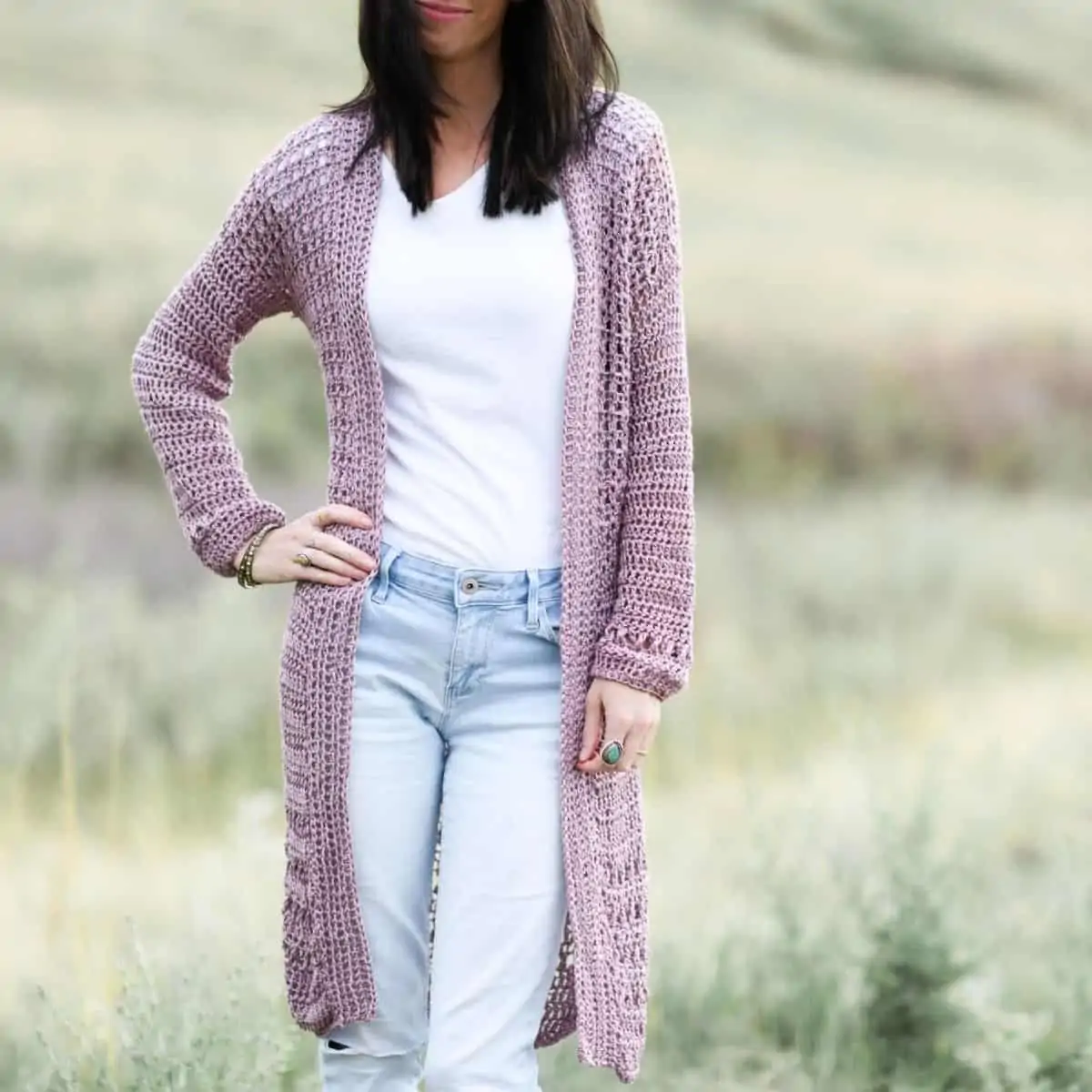 woman wearing a long lightweight yarn cardigan in a field