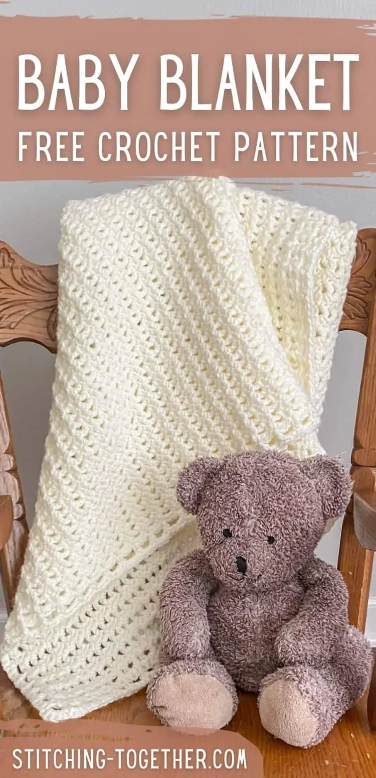crochet lace baby blanket draped on chair with stuffed bear next to it