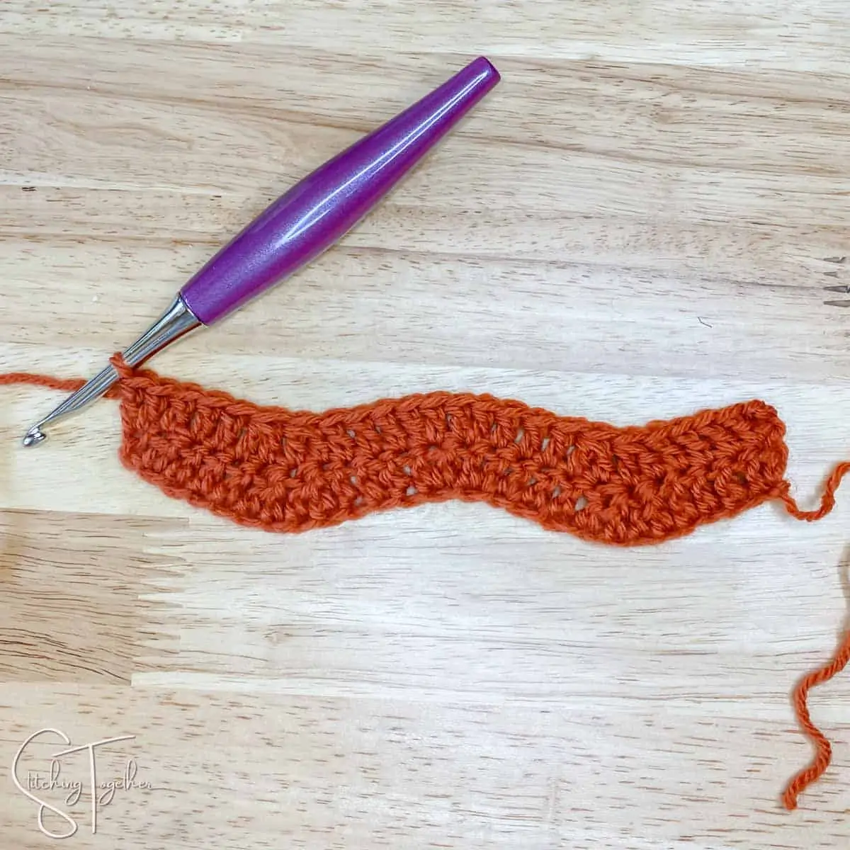a few rows of competed ripple stitch in orange yarn