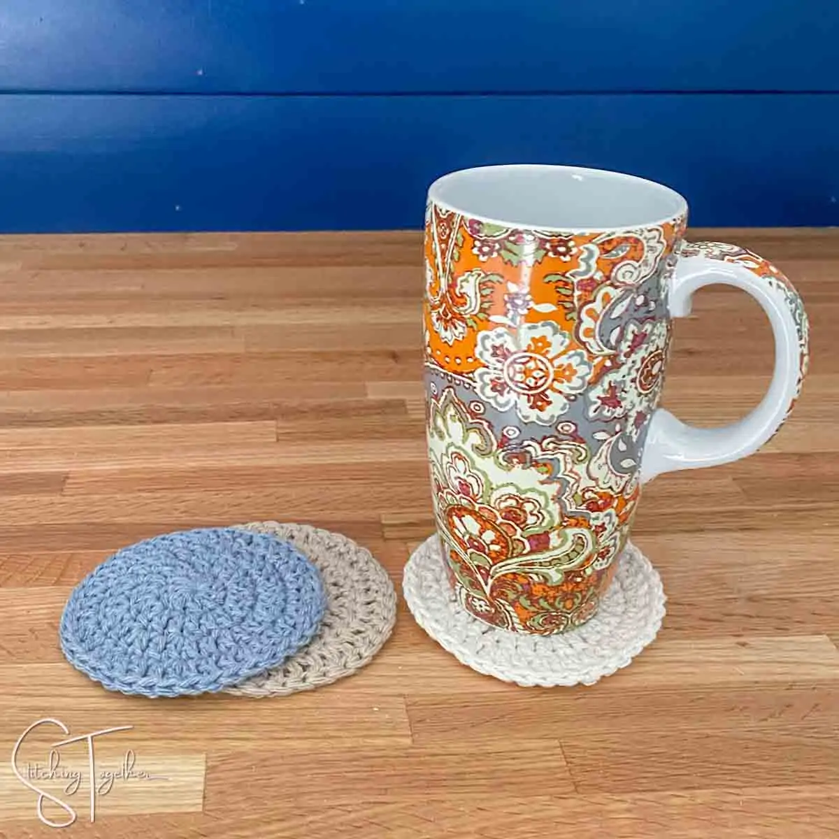 colorful mug sitting on a round crochet coaster with other coaster next to it