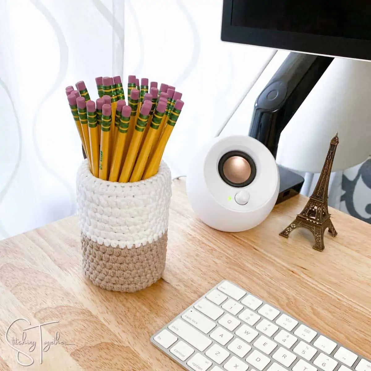 crochet pencil holder filled with pencils and sitting on a desk