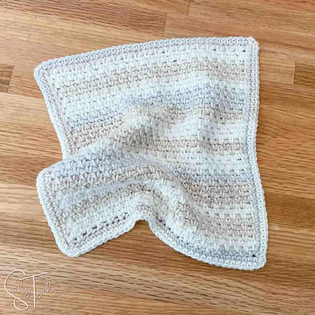 rumpled moss stitch crochet dishcloth laying on a counter
