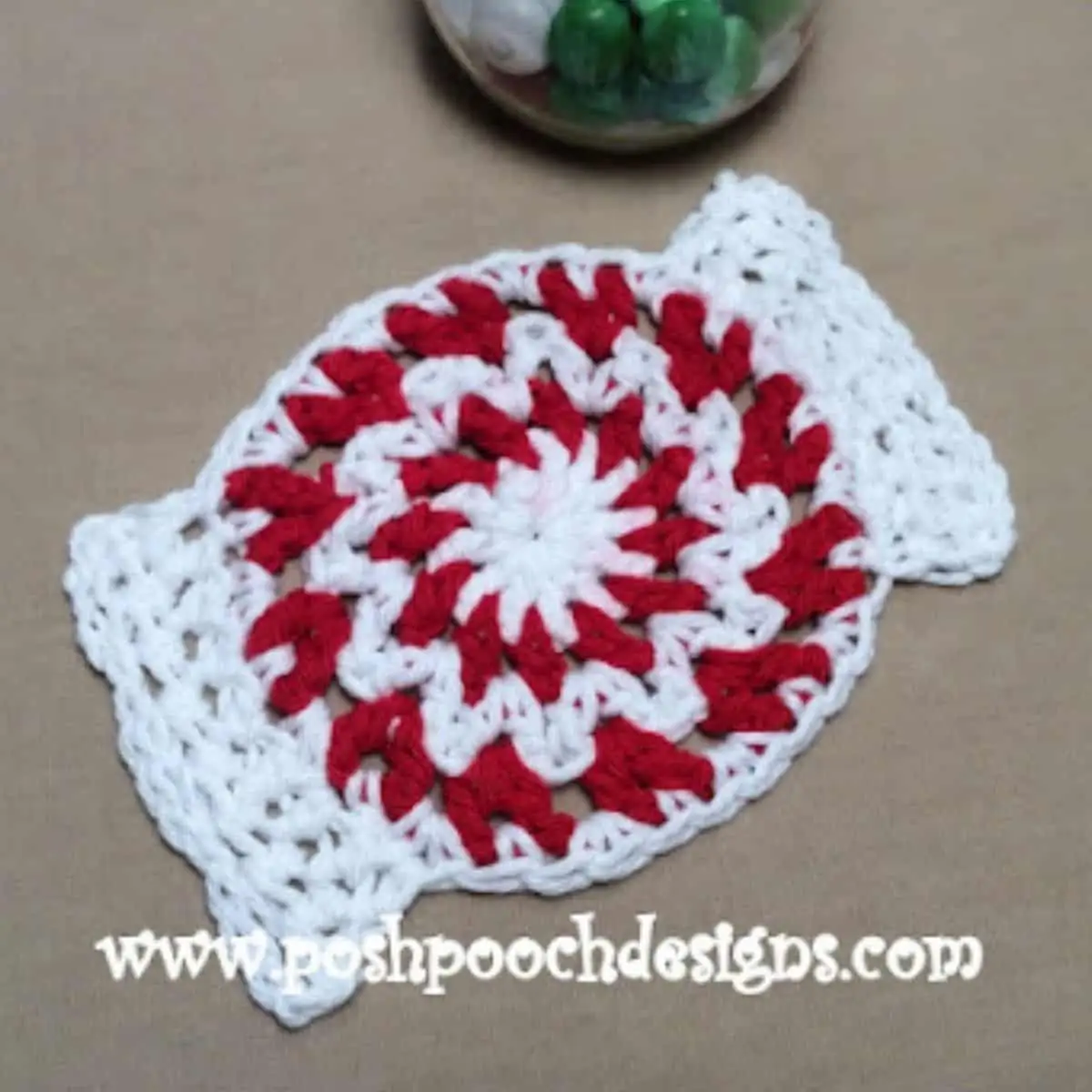 red and white coaster crocheted that looks like a peppermint