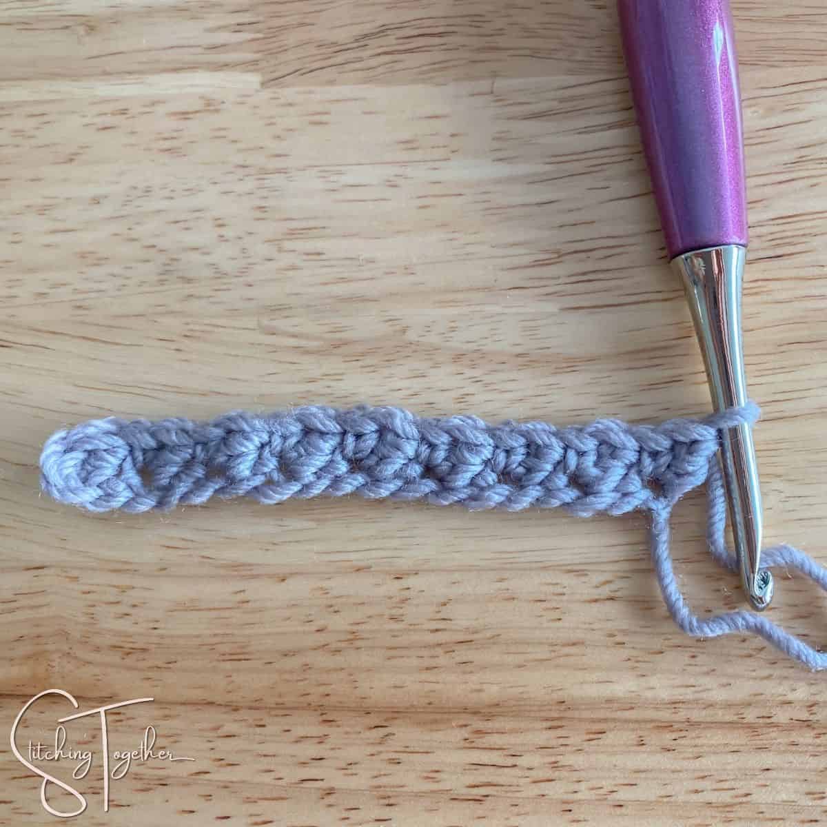 hook and yarn showing row 1 of suzette stitch crochet completed left handed