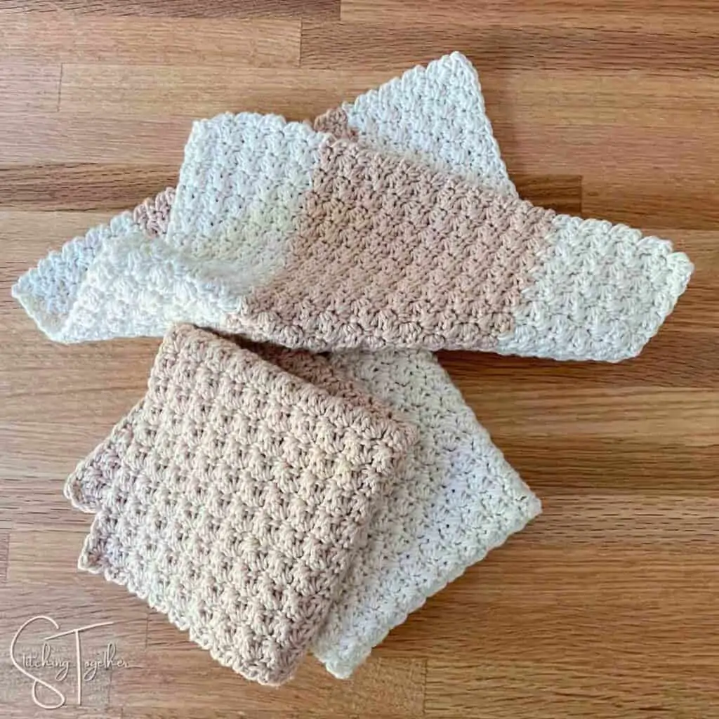 3 suzette stitch crochet washcloths on a countertop