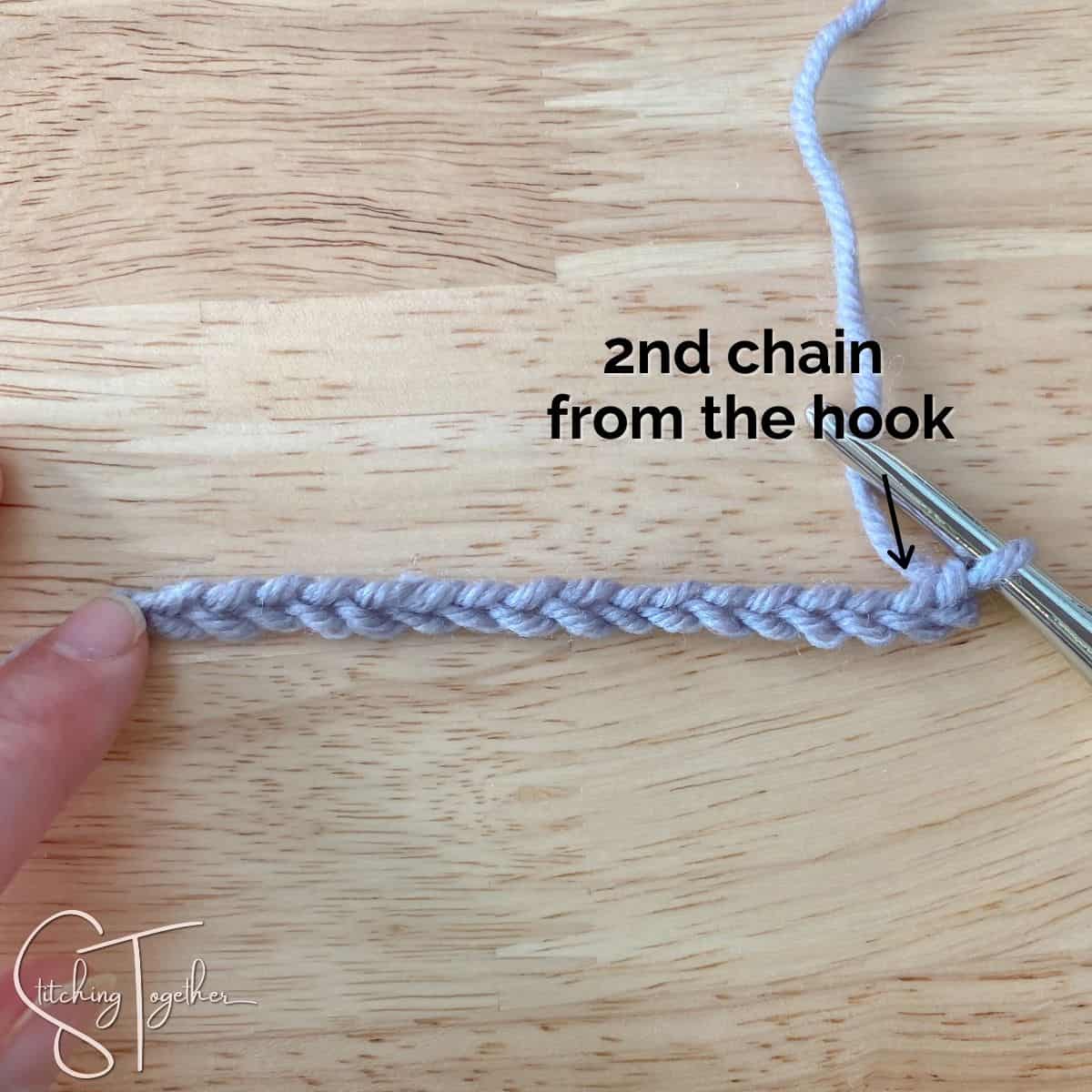 crochet chain with words and an arrow showing the second chain from the hook