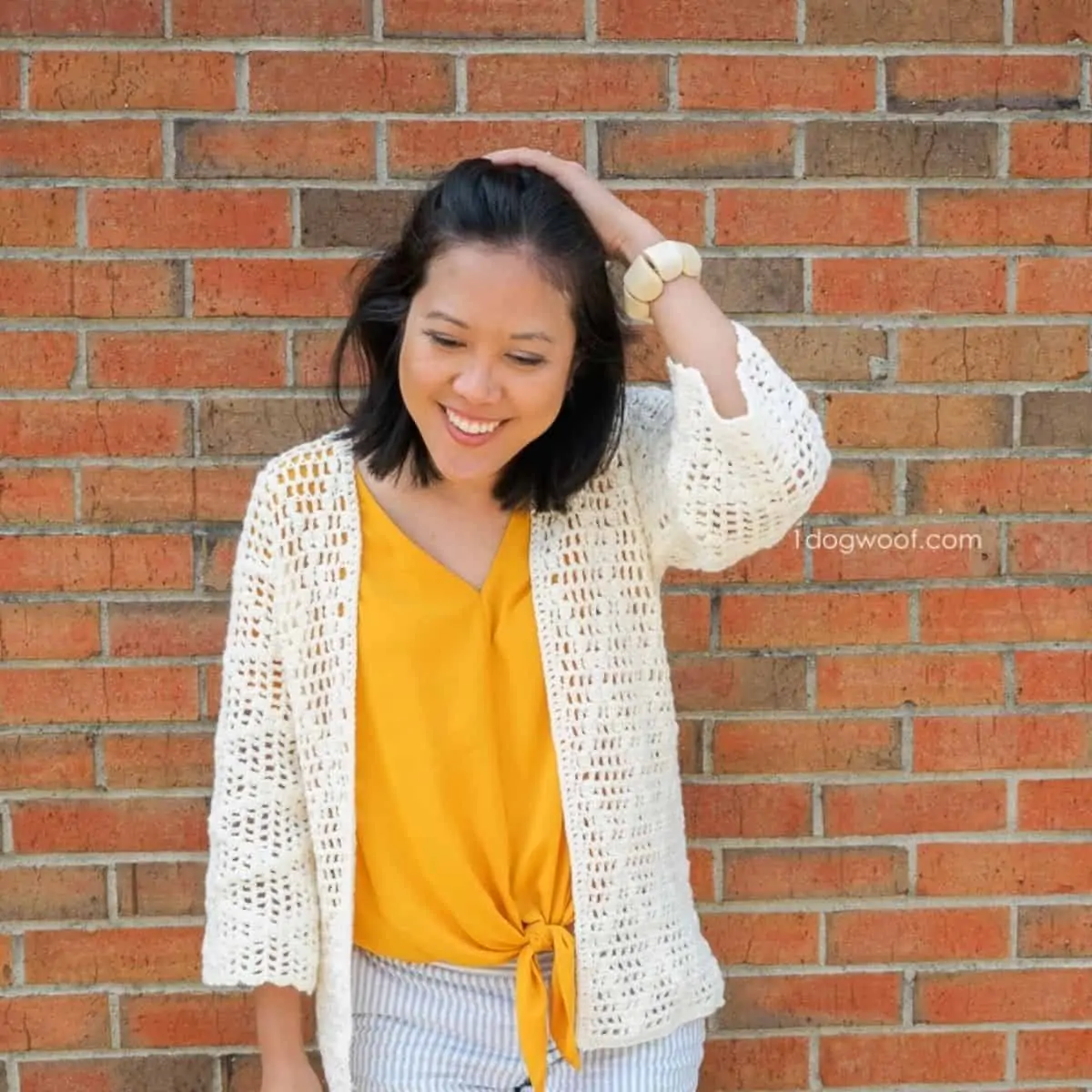 woman wearing bright yellow shirt and crocheted cardigan