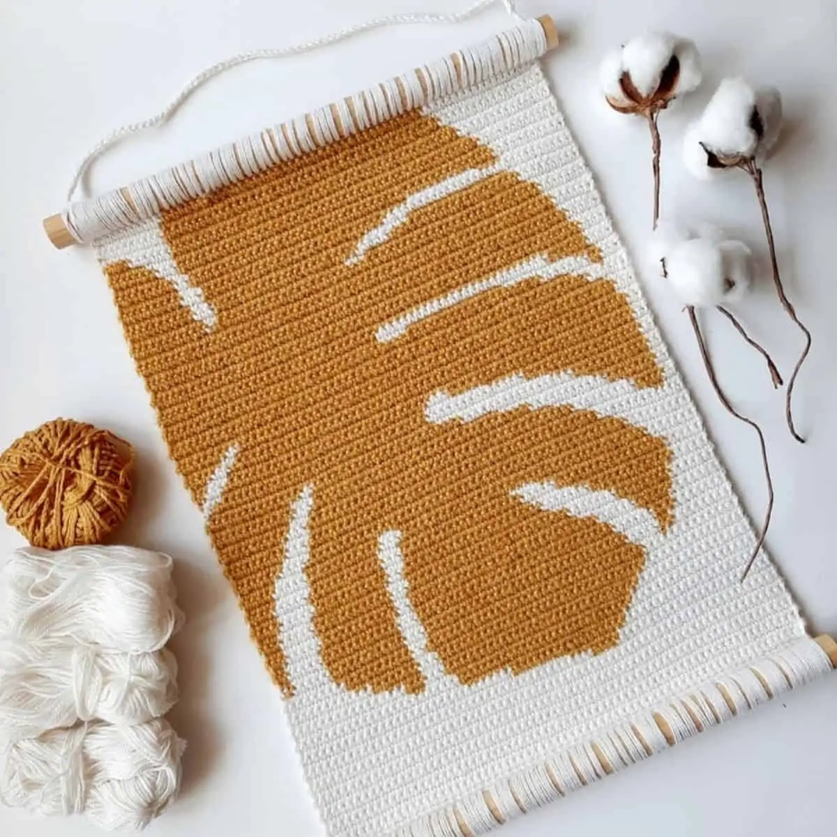 large crochet wall tapestry with a giant monstera leaf in the pattern