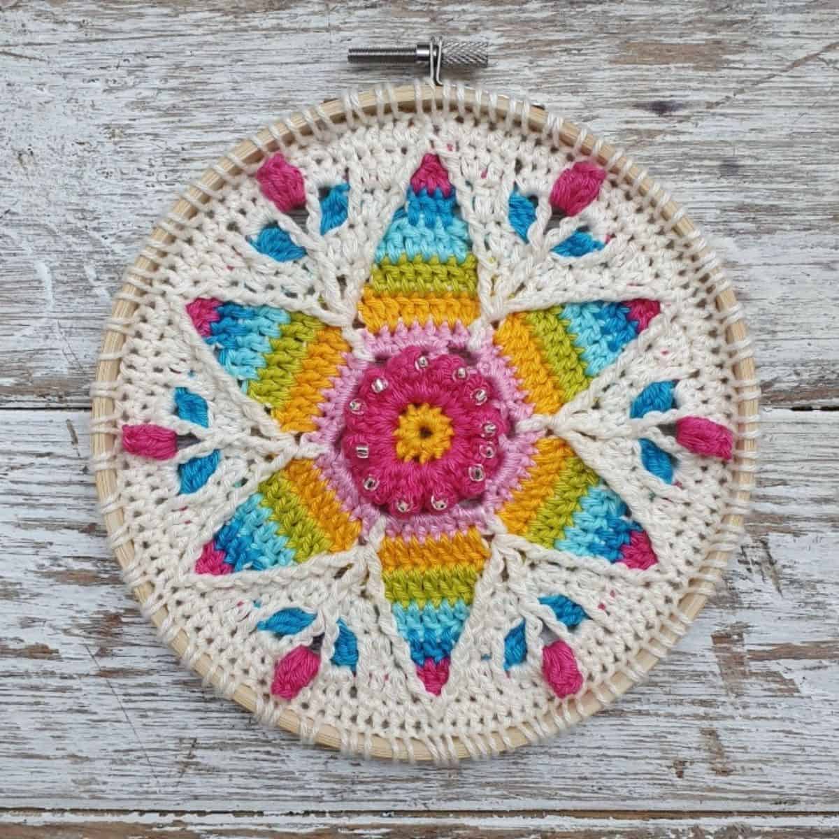 bastidor de bordado com o relevo de uma estrela colorida em crochê