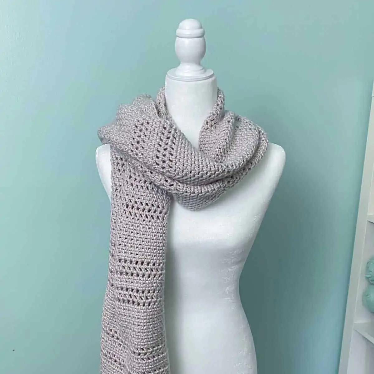 crocheted shawl folded and wrapped around the neck of a mannequin to look like a scarf
