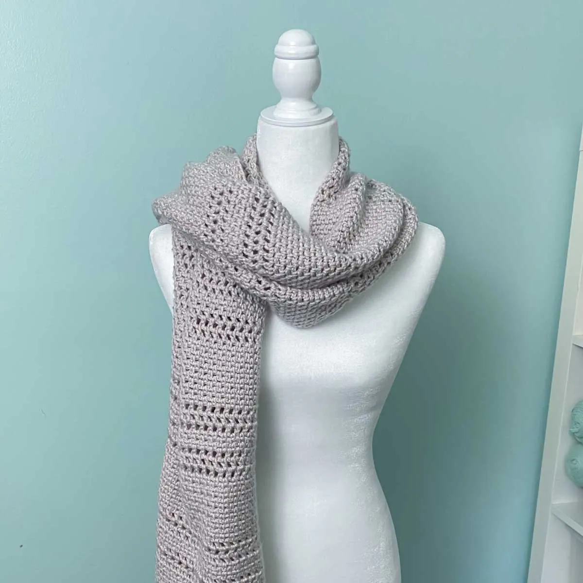 crocheted shawl folded and wrapped around the neck of a mannequin to look like a scarf