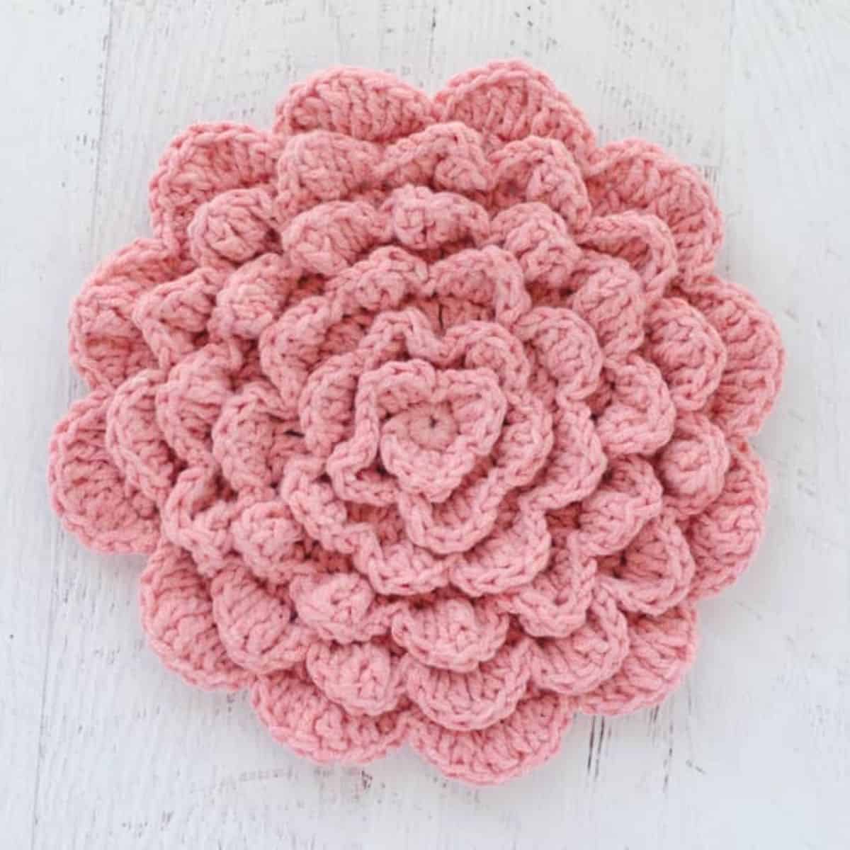 large pink crochet flower on a white background