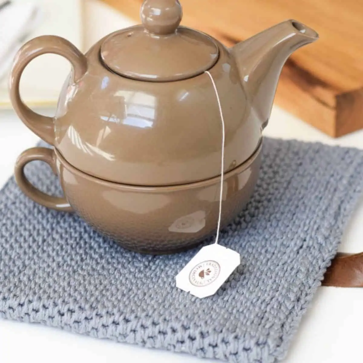 small teapot sitting on a thick crochet potholder trivet