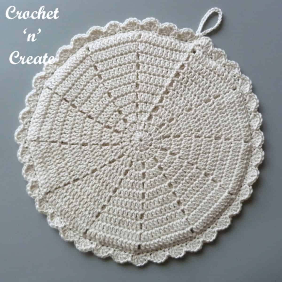 ivory colored crochet round potholder laying flat