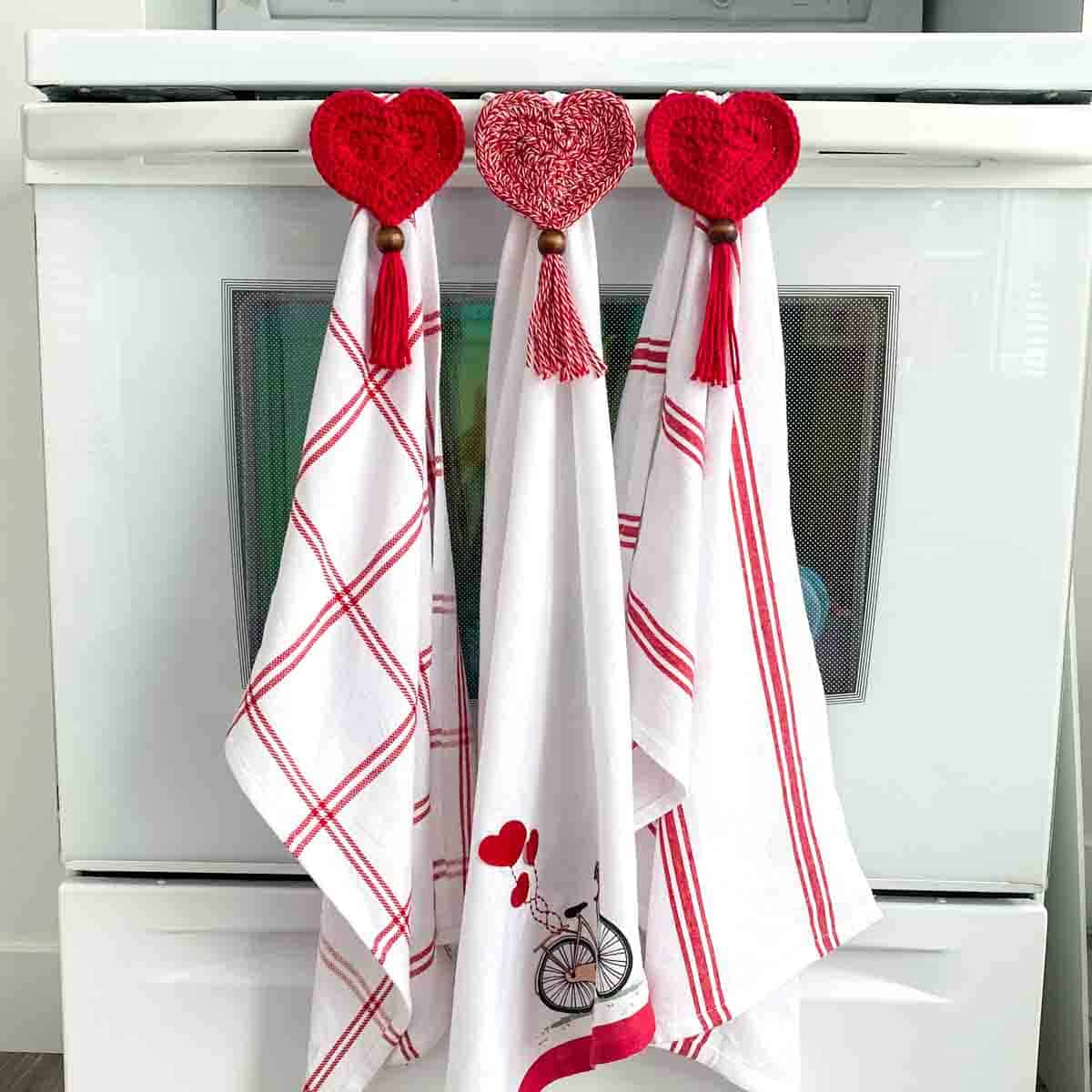 valentines dishtowels with heart crochet towel toppers hanging on an oven
