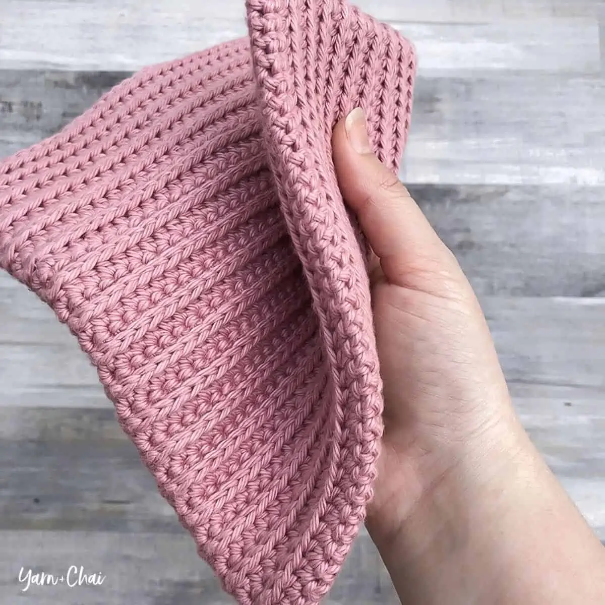 square crochet potholder being held 