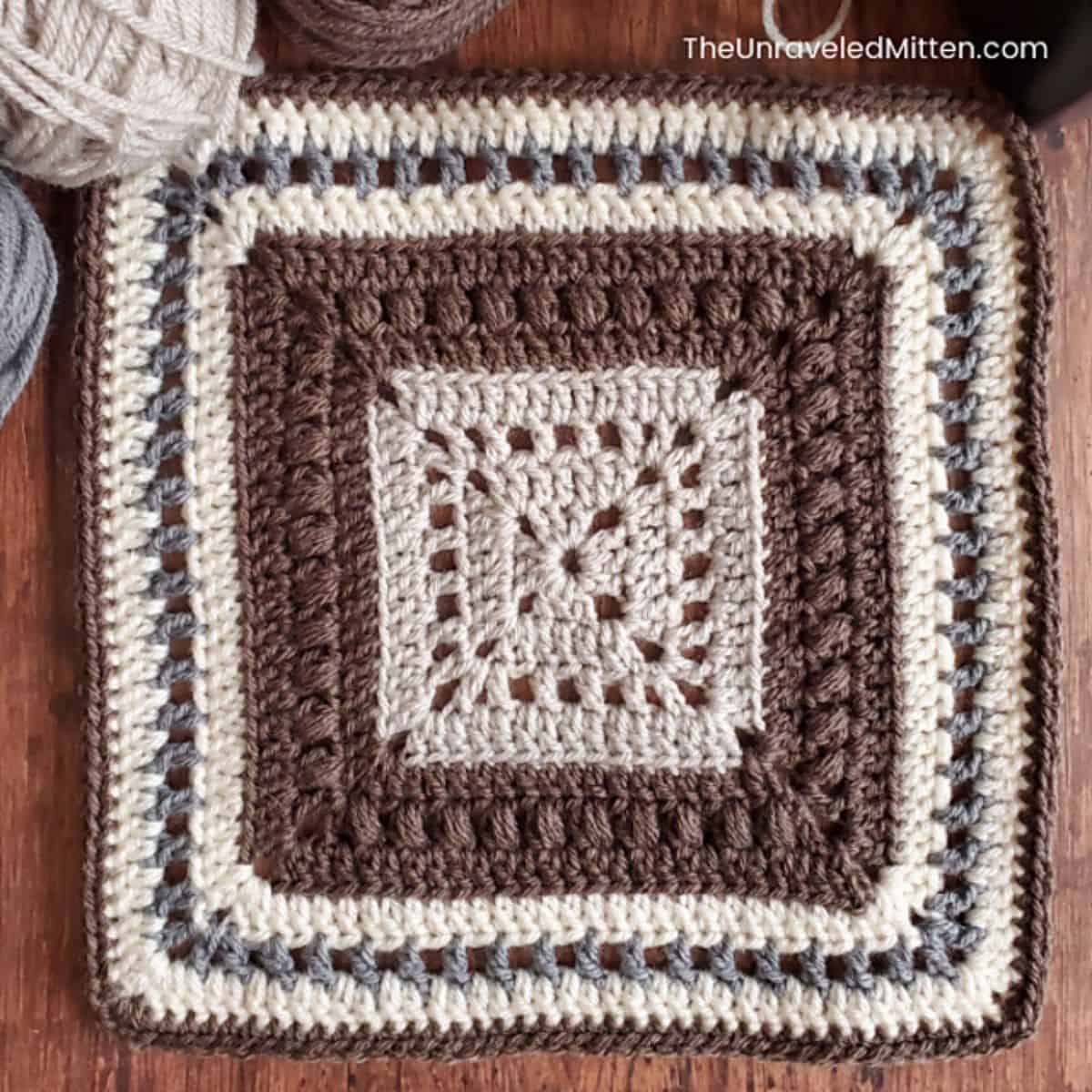brown gray and cream colored crochet square laying flat