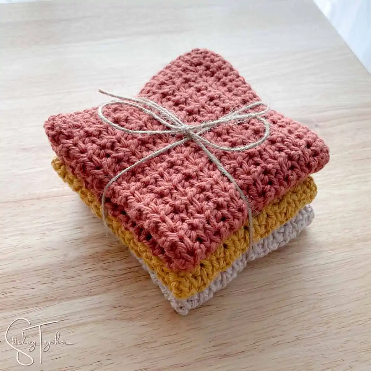 stack of folded crochet face cloths wrapped with jute twine