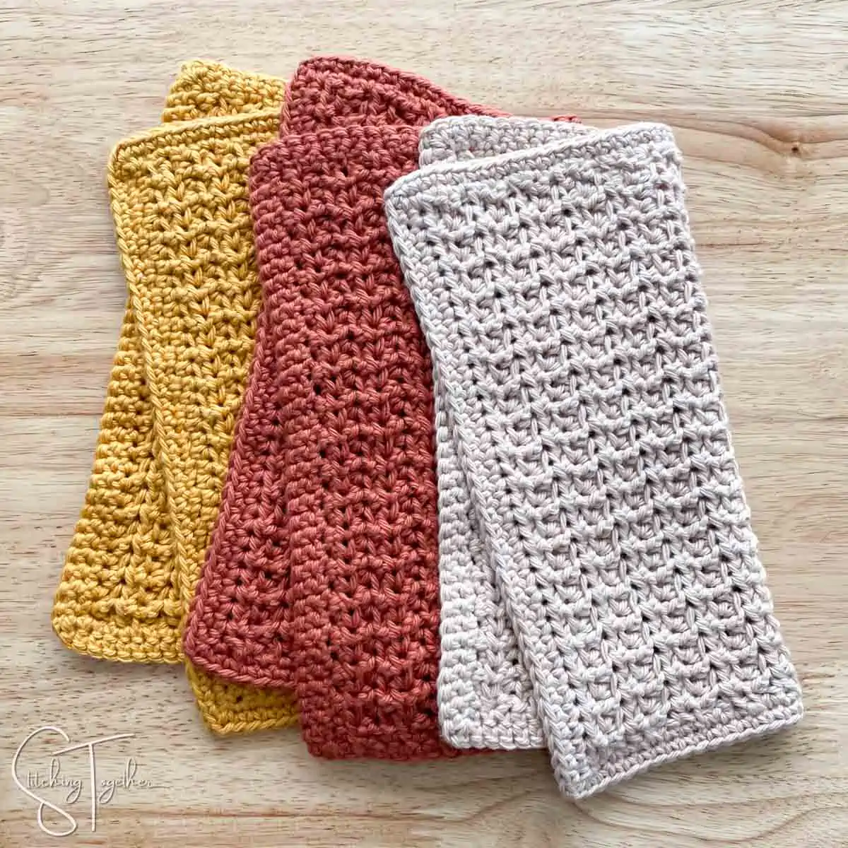 3 crochet washcloths folded in half laying somewhat stacked on each other