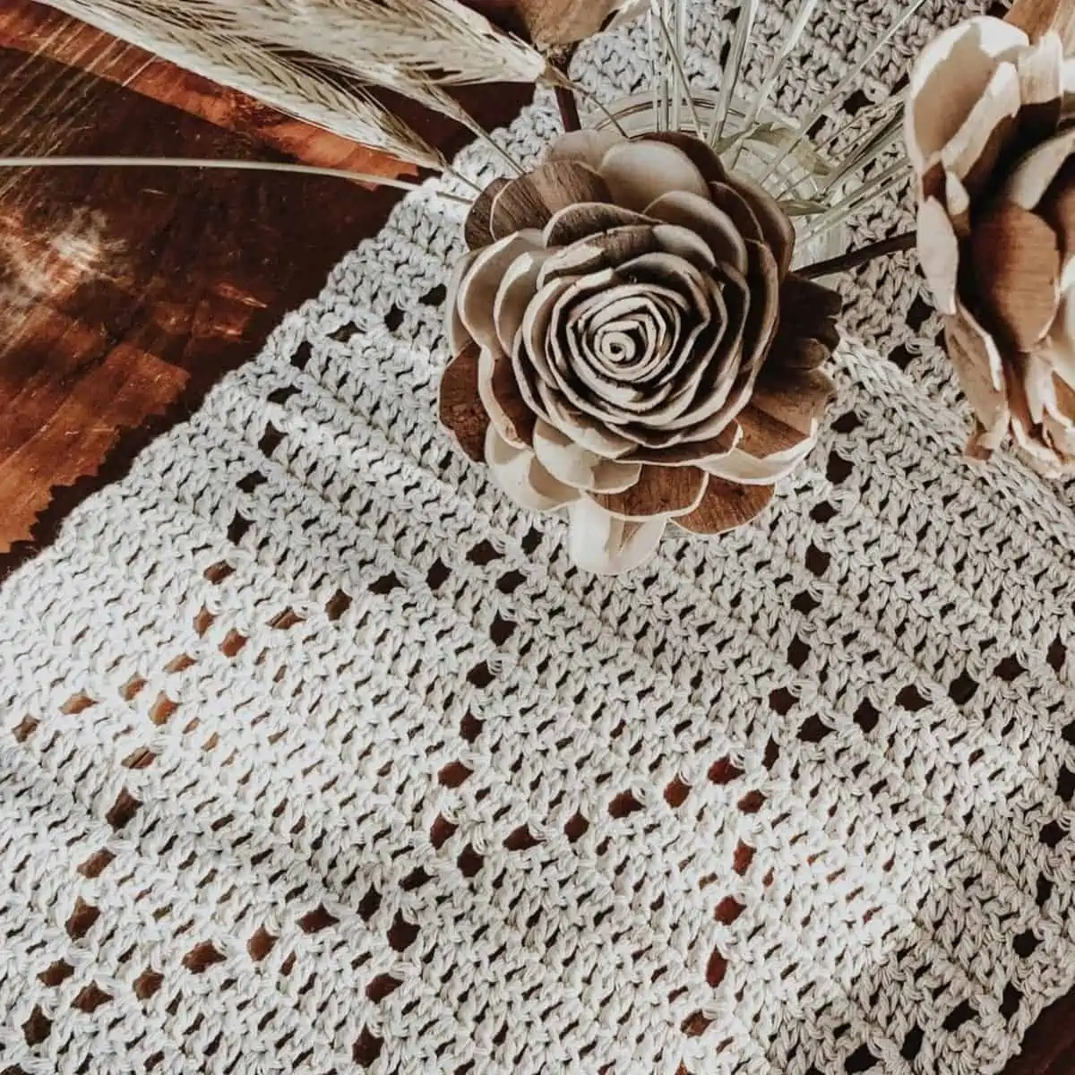 dried flowers and a crochet runner with a diamond pattern