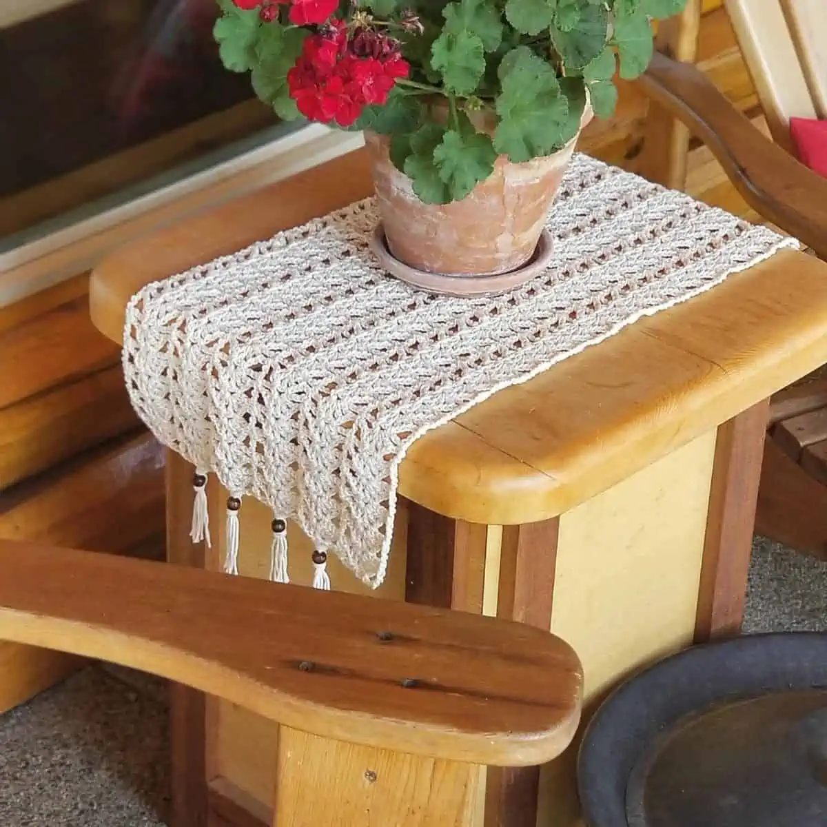 small side table with a crochet table runner and plant on it