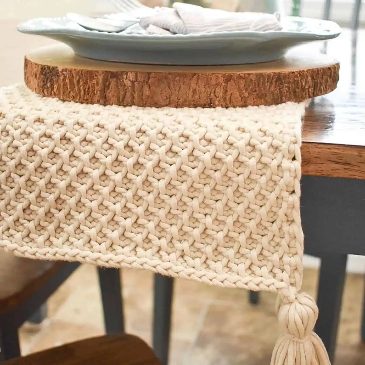 crochet table runner with tassels hanging off the end of a table