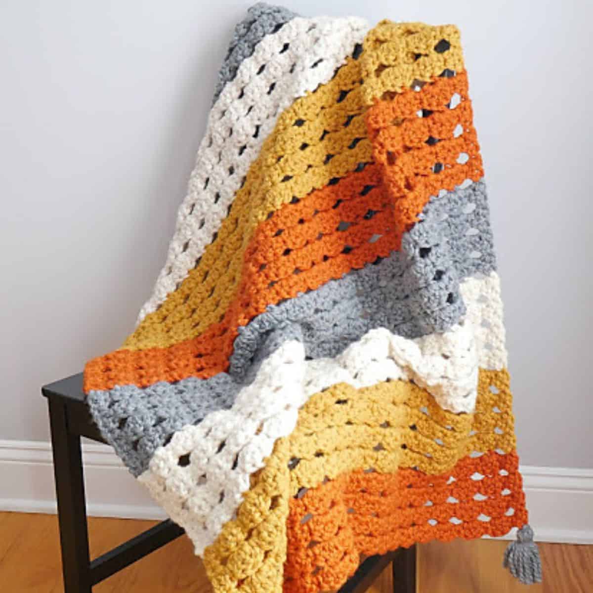 crochet fall afghan draped over a chair