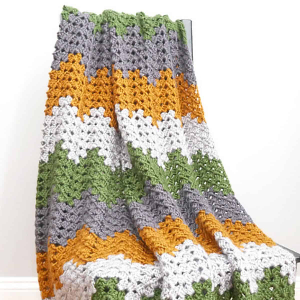 crochet fall blanket draped over a chair
