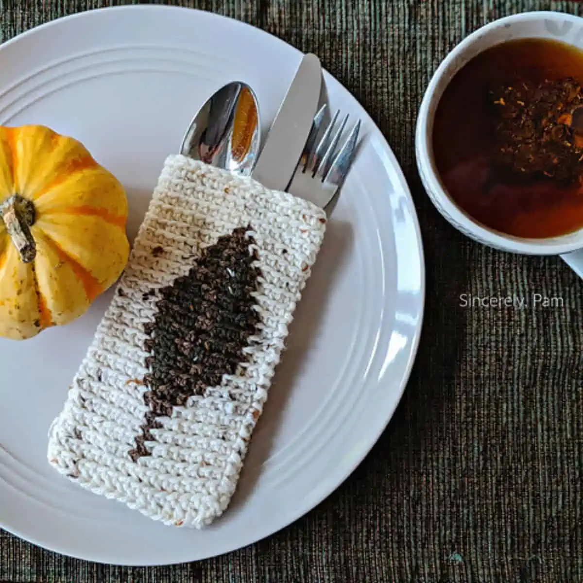 crochet cutlery holder displayed on a plate