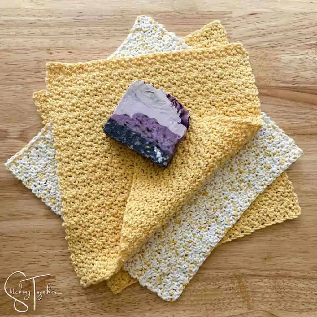stacked and folded crochet dishcloths with a fancy bar of soap on top