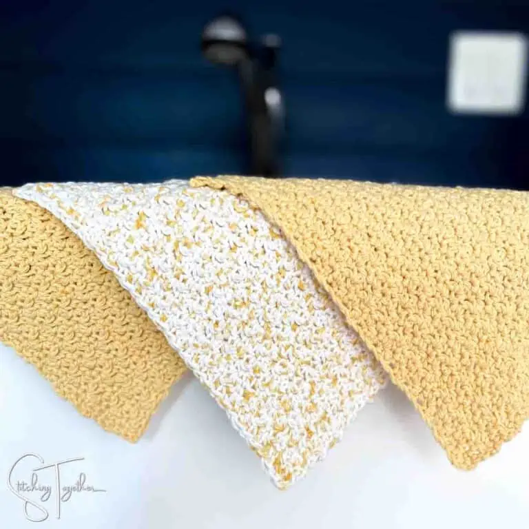 3 crochet dishcloths draped over the side of a counter