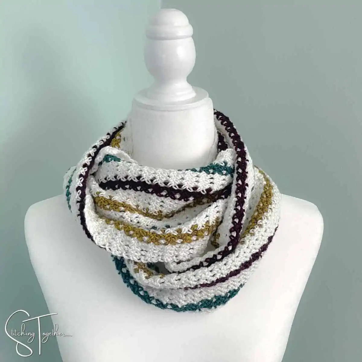 striped crochet infinity scarf wrapped around the neck of a mannequin