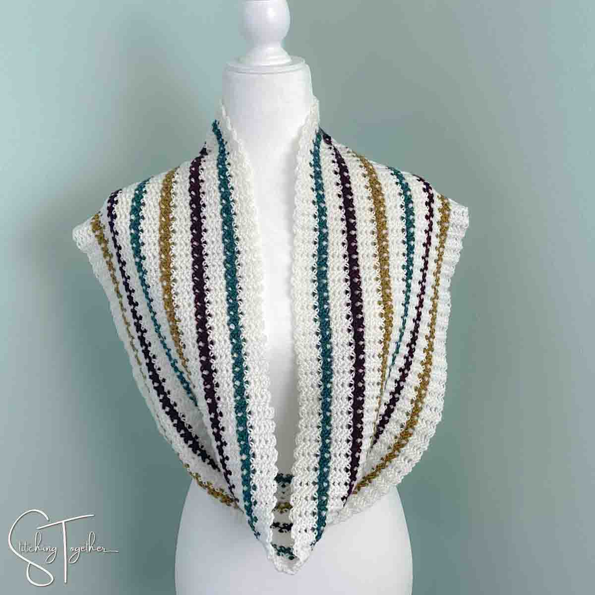 striped lightweight crochet infinity scarf draped around the neck of a mannequin