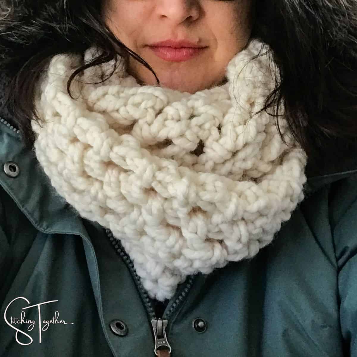 lady wearing a coat and bulky crochet scarf