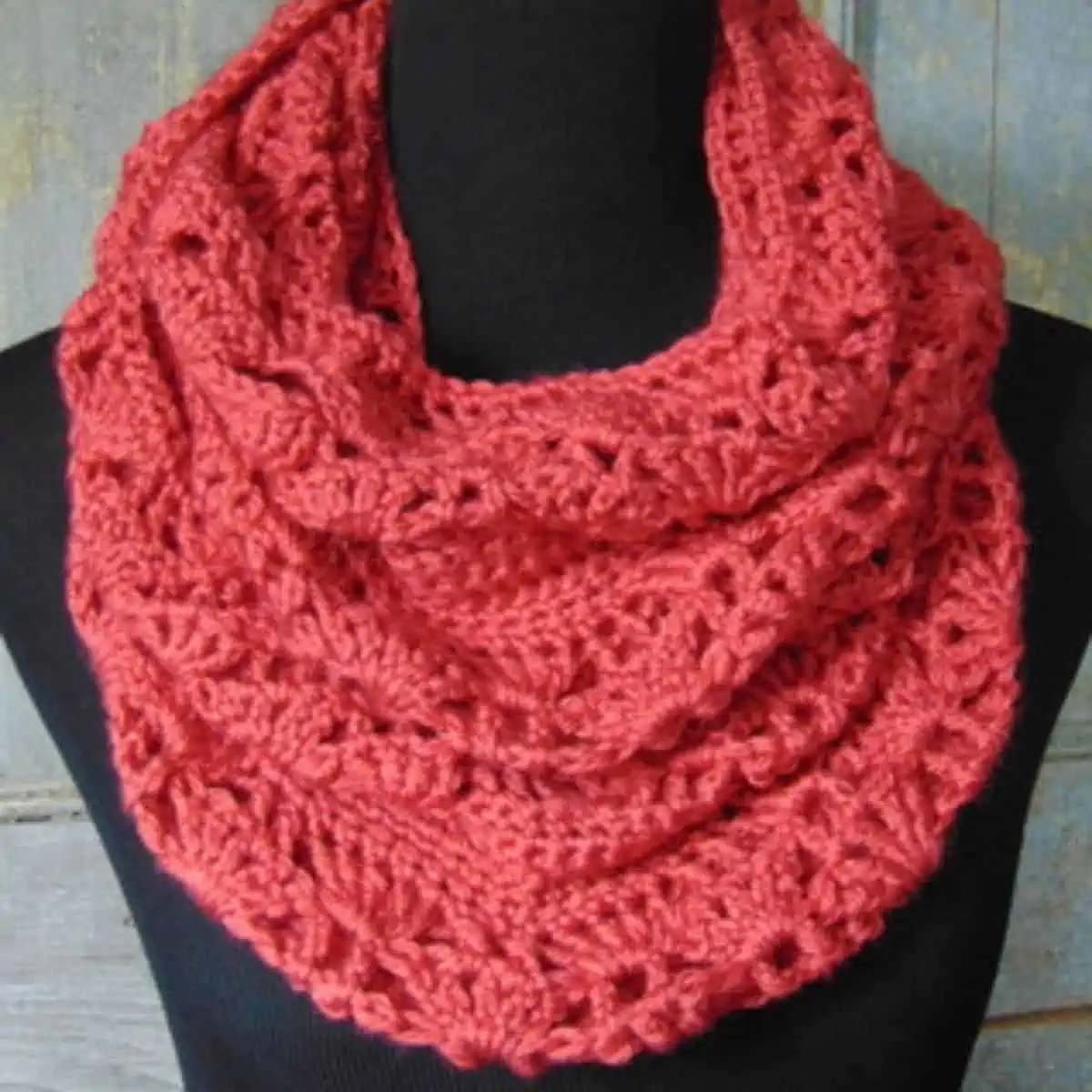coral colored lacy infinity scarf on a mannequin