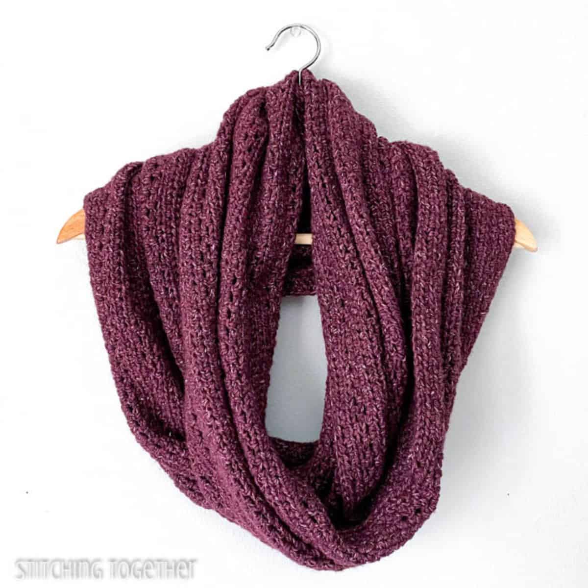 large crochet infinity scarf on a hanger