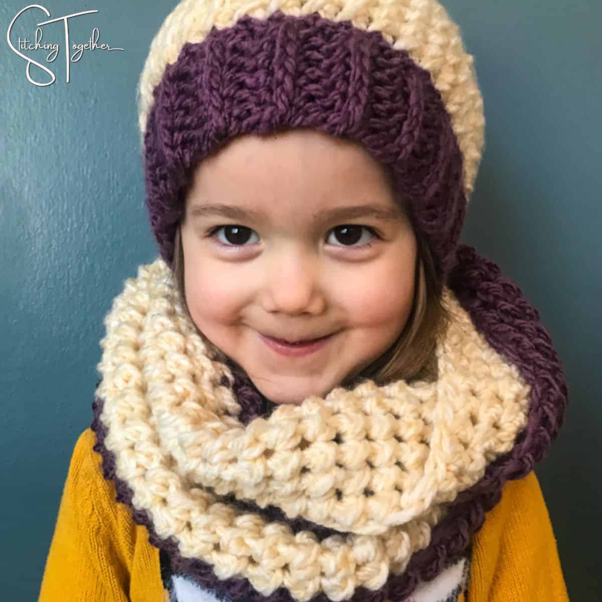 little girl wearing a matching crochet hat and scarf set