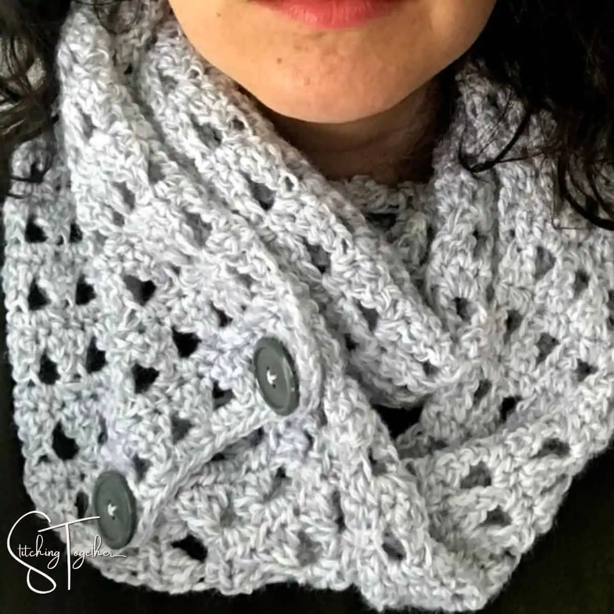 close up of gray crochet scarf with buttons