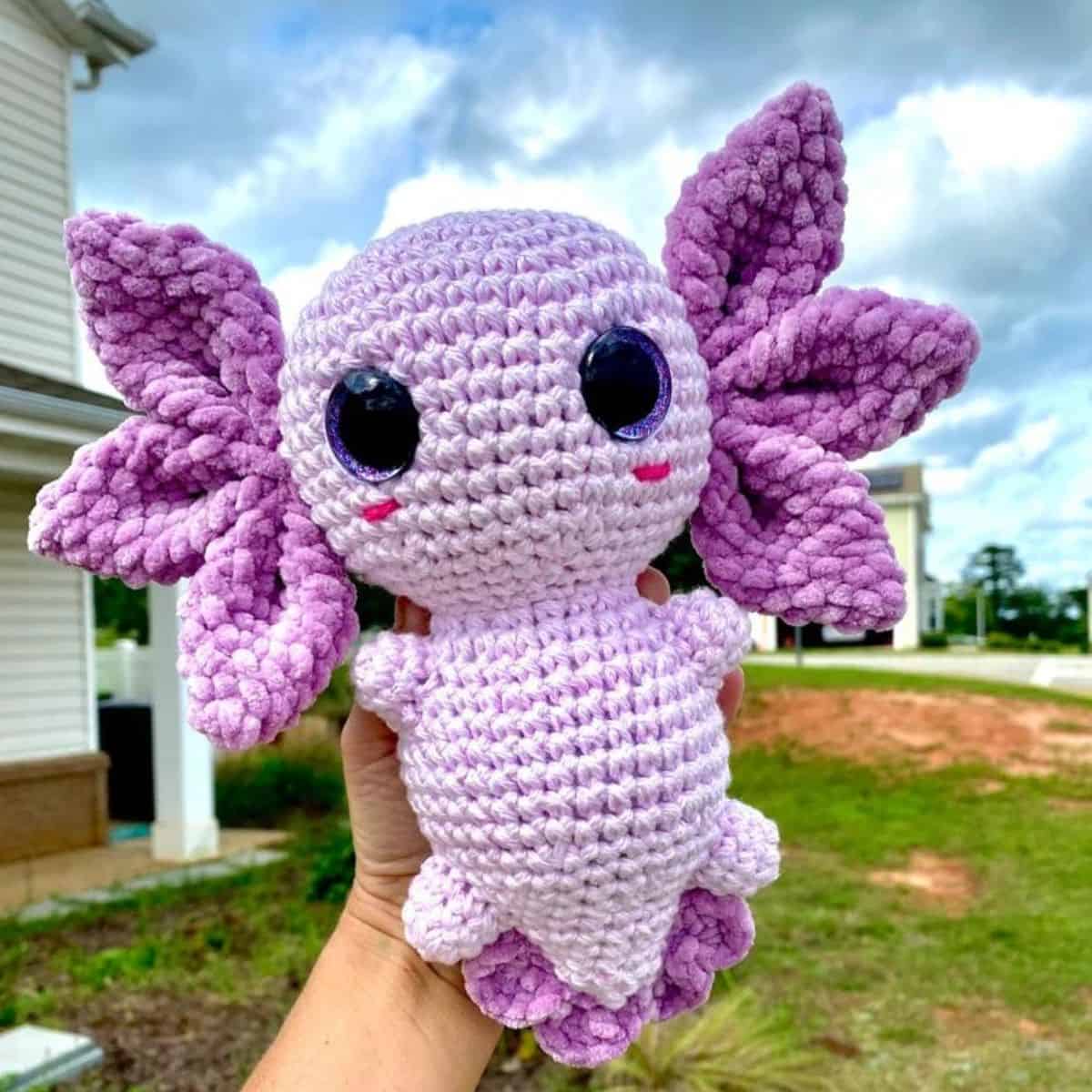 purple crochet axolotl being held up
